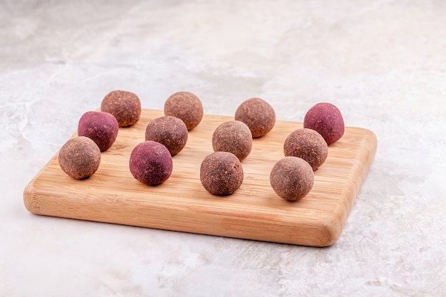 Zelfgemaakte raw vegan cacao energie ballen op houten dienblad