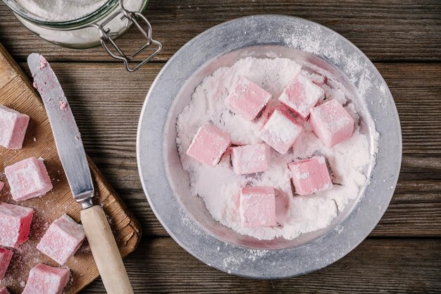 Foto zelfgemaakte roze marshmallows op houten achtergrond bovenaanzicht