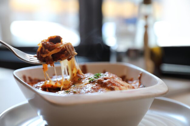 Zelfgemaakte rundvlees lasagne op schotel in restaurant, Italiaans eten