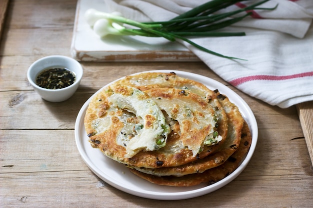 Zelfgemaakte smakelijk lente-uitjes pannenkoeken en een bos van groene uien. Rustieke stijl.