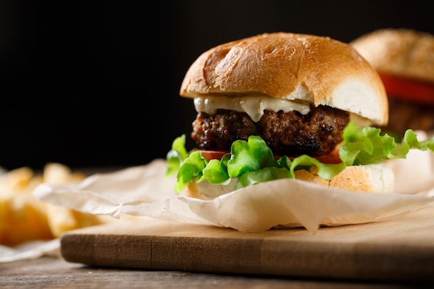 Zelfgemaakte smakelijke hamburger en frietjes op houten tafel