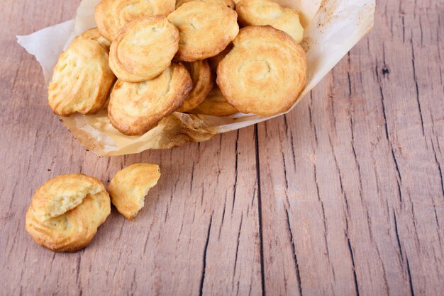 Zelfgemaakte smakelijke koekjes met perkamentpapier op de tafel.