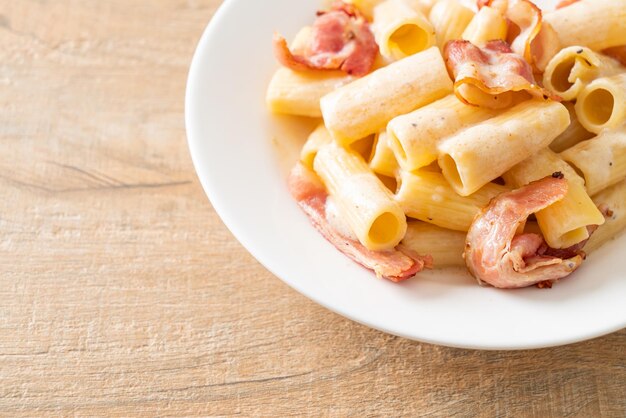 zelfgemaakte spaghetti rigatoni pasta met witte saus en spek Italiaans eten stijl