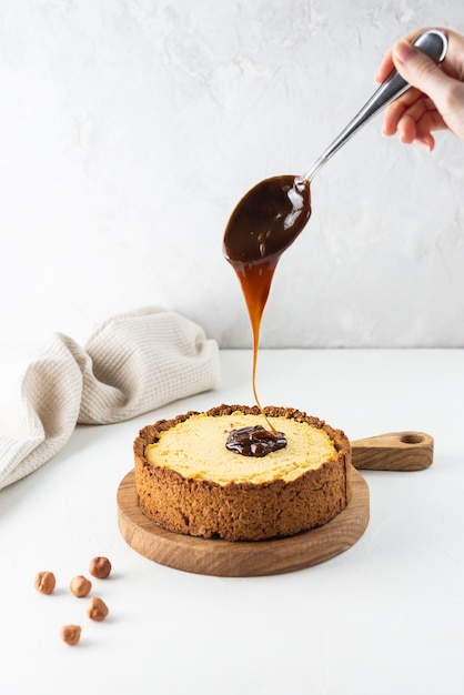 Zelfgemaakte tofu cake met karamel op een houten bord.