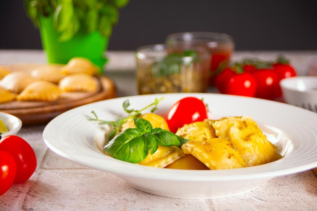 Zelfgemaakte traditionele italiaanse ravioli pasta met basilicum en tomaat cherry groenten op tafel