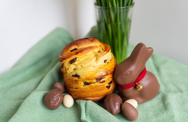 Zelfgemaakte traditionele paasgebakjes liggen op een groen servet met een boeket bloemen, een konijn, chocolade-eieren, Pasen bakken en decoratie