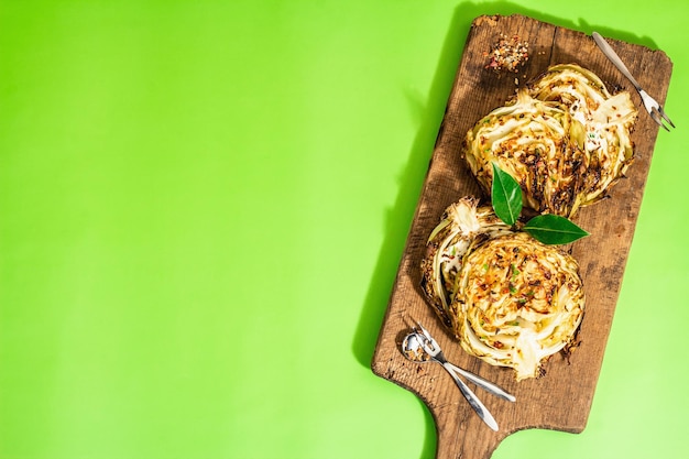 Zelfgemaakte veganistische koolsteaks met kruiden en specerijen Gezonde voeding klaar om te eten op een snijplank