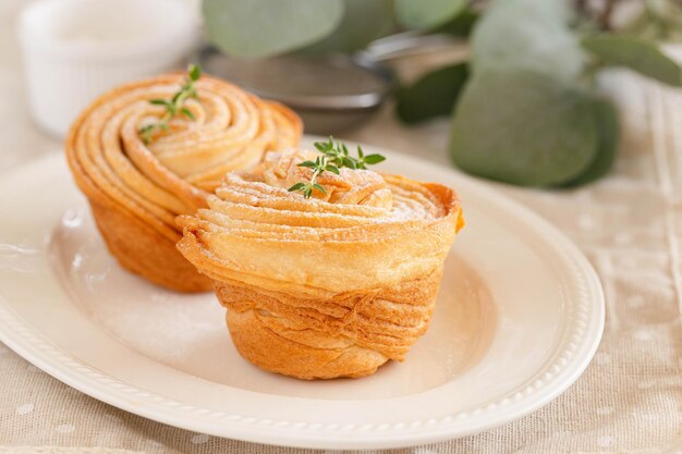 Zelfgemaakte versgebakken cruffin bestrooien met glazuur of poedersuiker decoreren met tijmblad