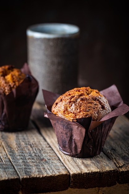 Zelfgemaakte versgebakken wortelmuffins met hazelnoot en sinaasappel op houten ondergrond