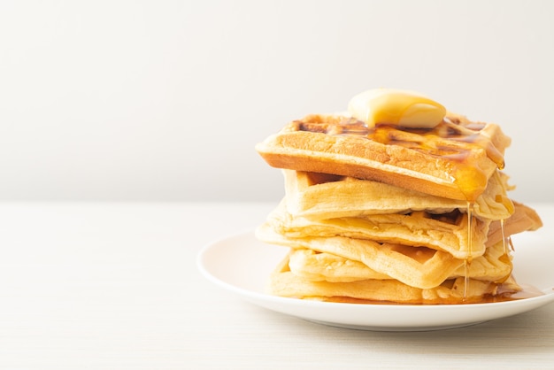 zelfgemaakte wafelstapel met boter en honing of ahornsiroop