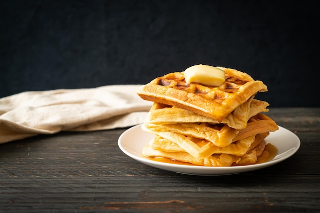 zelfgemaakte wafelstapel met boter en honing of ahornsiroop