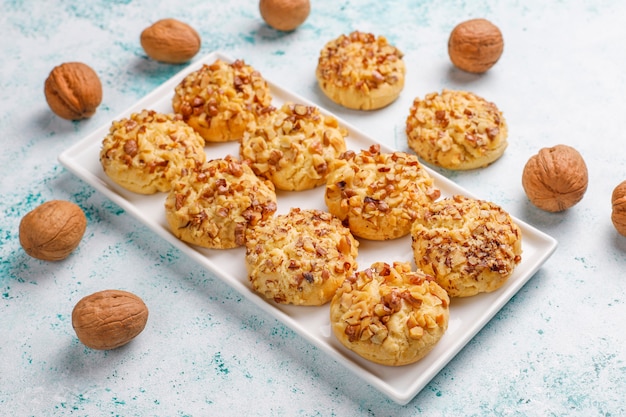 Zelfgemaakte walnoot cookies in witte plaat met walnoten, bovenaanzicht