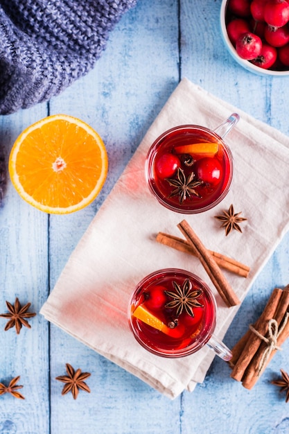 Zelfgemaakte warme glühwein met oranje kaneel en bessen in glazen boven- en verticaal zicht