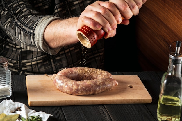 Zelfgemaakte worst koken met de handen van de chef