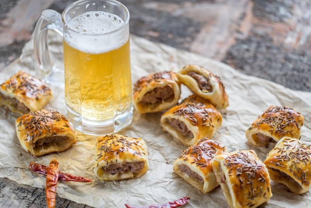 Zelfgemaakte worstenbroodjes met mok bier