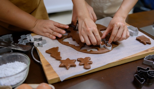 Zelfgemaakte Xmas cookie voor Kerstmis en Gelukkig Nieuwjaar. Vrouw peperkoek koken met vriend en familie op wintervakantie thuis.