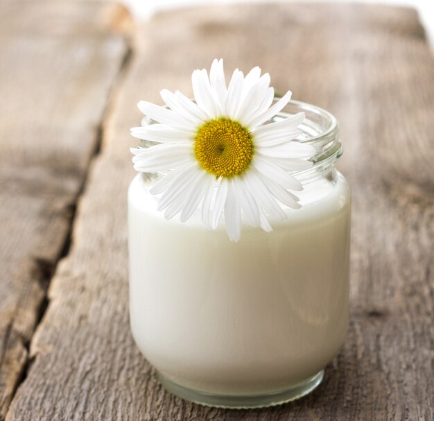 Zelfgemaakte yoghurt in een glazen pot op oude houten achtergrond