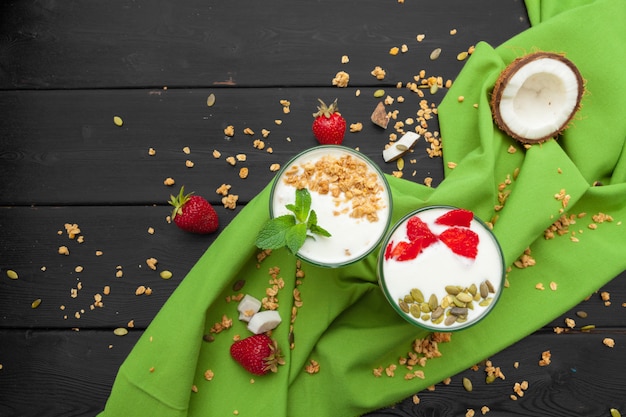 Zelfgemaakte Yoghurt met bovenaanzicht van granola, fruit en kokosnoot op houten