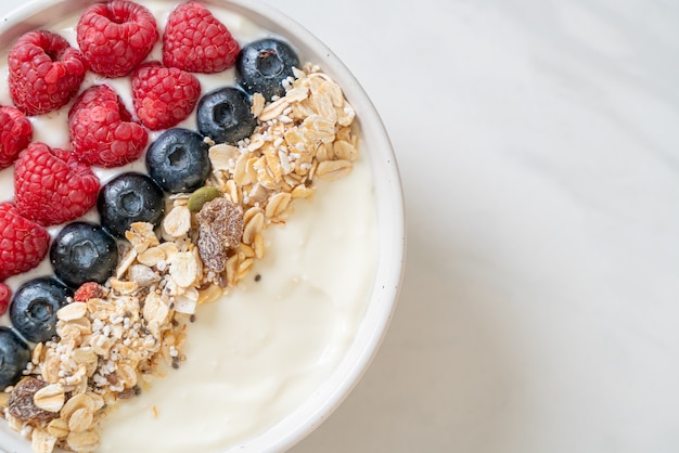 zelfgemaakte yoghurtkom met framboos, bosbes en granola. gezonde voedingsstijl