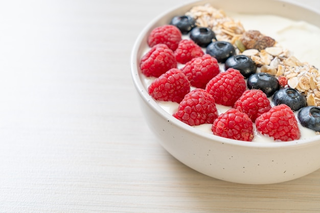 zelfgemaakte yoghurtkom met frambozen, bosbessen en granola - gezonde voedingsstijl