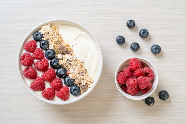 zelfgemaakte yoghurtkom met frambozen, bosbessen en muesli - gezonde voedingsstijl