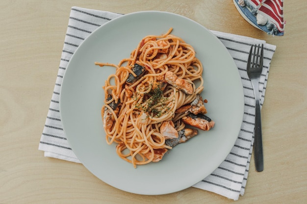 Zelfgemaakte zalmspaghetti geserveerd op witte schotel