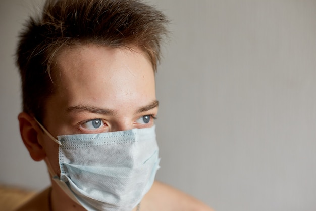 Zelfisolatie en quarantaine, portret van een tiener in een medisch masker