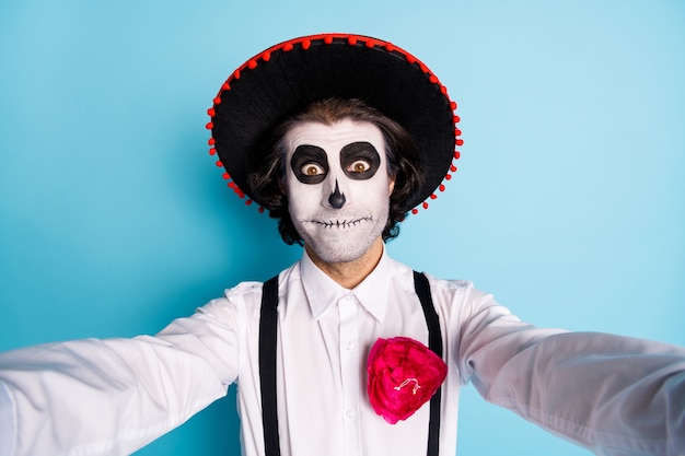 Zelfportret van zijn aardige knappe griezelige vrolijke grappige kerel heer met sombrero zombie make-up look outfit feestelijk evenement Santa Muerte geïsoleerd helder levendig glans levendige blauwe kleur achtergrond