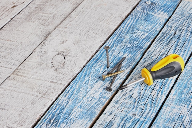 Zelftappende schroef en schroevendraaier op houten plank achtergrond kopie ruimte