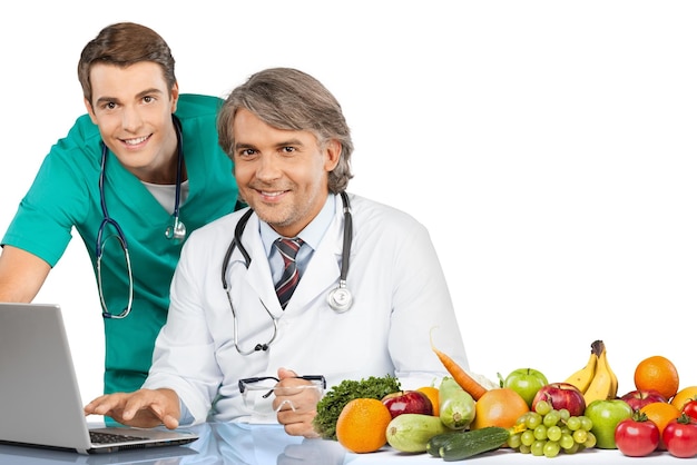 Zelfverzekerd medisch team in het ziekenhuis met laptop en fruit