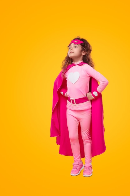 Zelfverzekerd superheldenkind in roze outfit