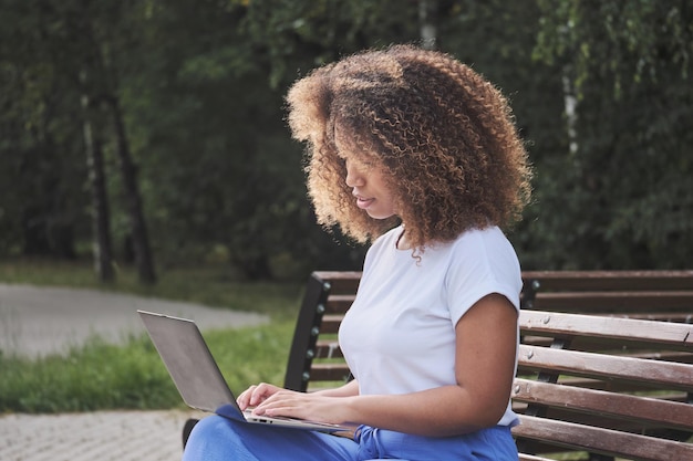 Zelfverzekerde biraciale dame gericht op het typen van sms, online onderwijs