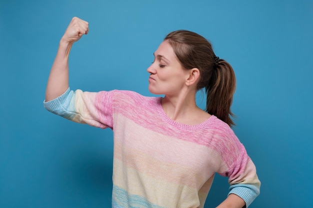 Zelfverzekerde blanke vrouw die haar biceps buigt