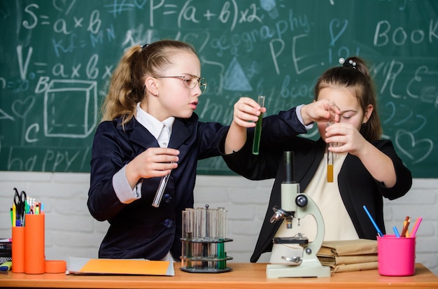 Zelfverzekerde dokters Kleine meisjes in schoollaboratorium biologie onderwijs wetenschappelijke experimenten in biologielaboratorium Biologieles Terug naar school Kleine wetenschapper werkt met microscoop Chemieonderzoek