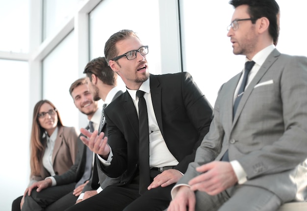 Zelfverzekerde gekwalificeerde jonge manager zit met zijn collega's op een seminar