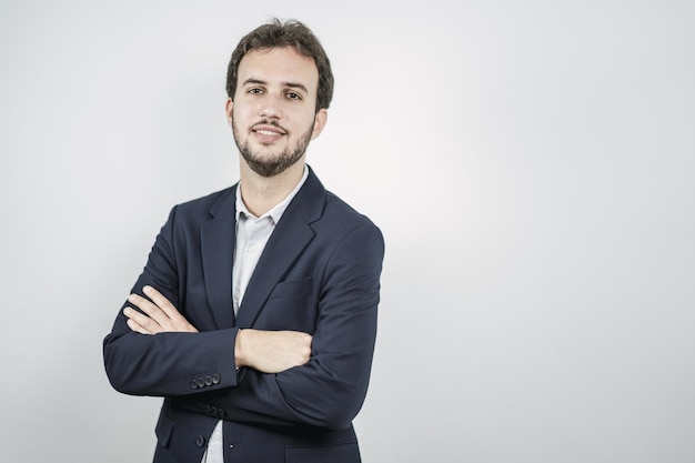 Zelfverzekerde jonge Spaanse baarde zakenman met gekruiste armen geïsoleerd op een witte achtergrond