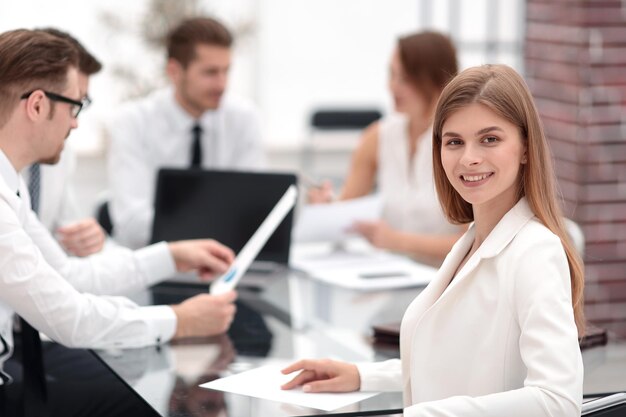 Zelfverzekerde jonge zakenvrouw zit aan haar Deskphoto met kopieerruimte