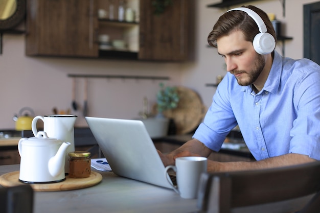 Zelfverzekerde man met een headset die spreekt en kijkt naar zakelijke webinar-training, luisterend naar een lezing.