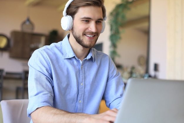 Zelfverzekerde man met een headset die spreekt en kijkt naar zakelijke webinar-training, luisterend naar lezing.