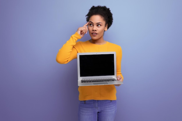 Zelfverzekerde slimme jonge Spaanse bedrijfsdame van een jaar oud met afro met een laptop in haar handen