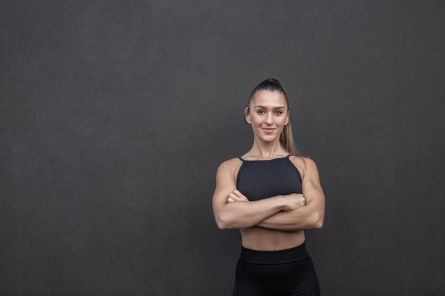 Zelfverzekerde sportvrouw met gekruiste armen