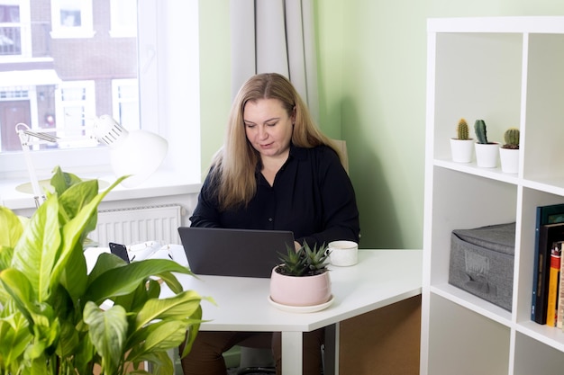 Zelfverzekerde vrouw van middelbare leeftijd die vanuit huis werkt in quarantaine vrouwelijk zakelijk portret met laptop