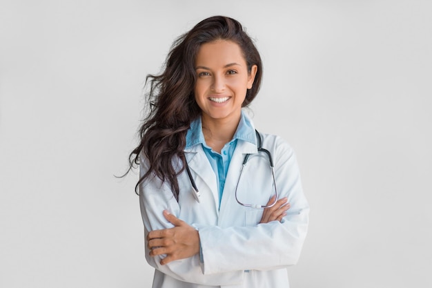 Zelfverzekerde vrouwelijke arts met gekruiste stethoscooparmen