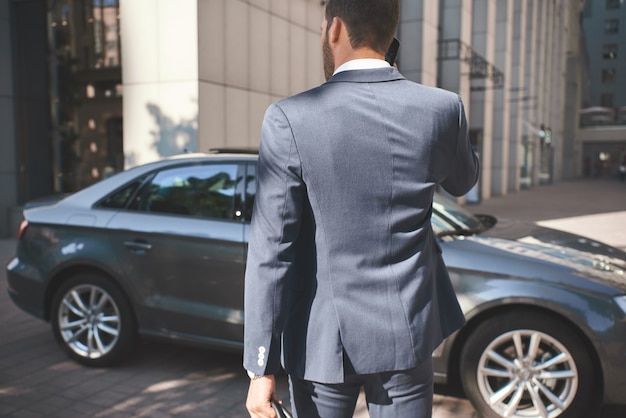 Zelfverzekerde zakenman jonge zakenman komt naar de auto