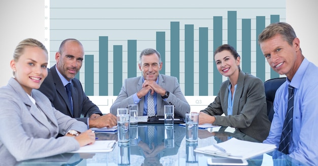 Zelfverzekerde zakenmensen aan vergadertafel tegen grafiek