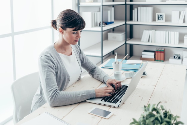 Zelfverzekerde zakenvrouw die aan het bureau werkt