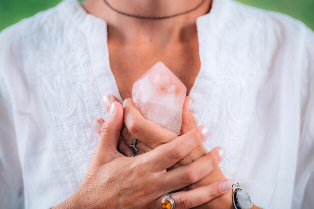 Foto zelfwaarde meditatie concept handen met een roos kwarts kristal mediteren