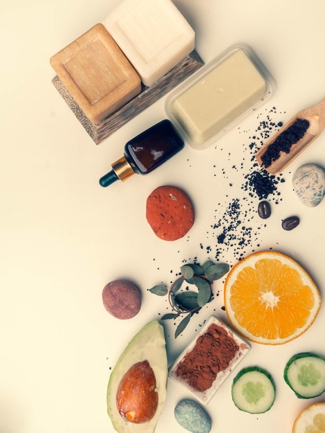 Zelfzorg producten van natuurlijke biologische ingrediënten Moderne geneeskunde apotheker Butters zeep serum scrub sinaasappelschijfjes avocado stenen voor massage en droge bloemen rozen Flat lay stijl