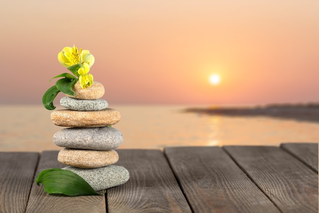 Photo zen basalt stones and leaves on blurred background