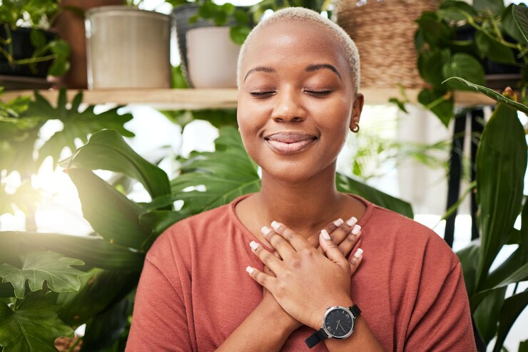 Photo zen breathing and calm woman by plants for breathing exercise in meditation in a nursery breathe gratitude and young african female person with a relaxing mindset by an indoor greenhouse garden